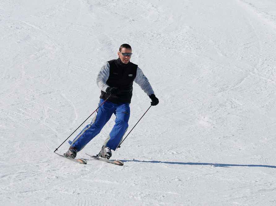 Skieur en descente sur une piste de la station de Prabouré par temps ensoleillé.