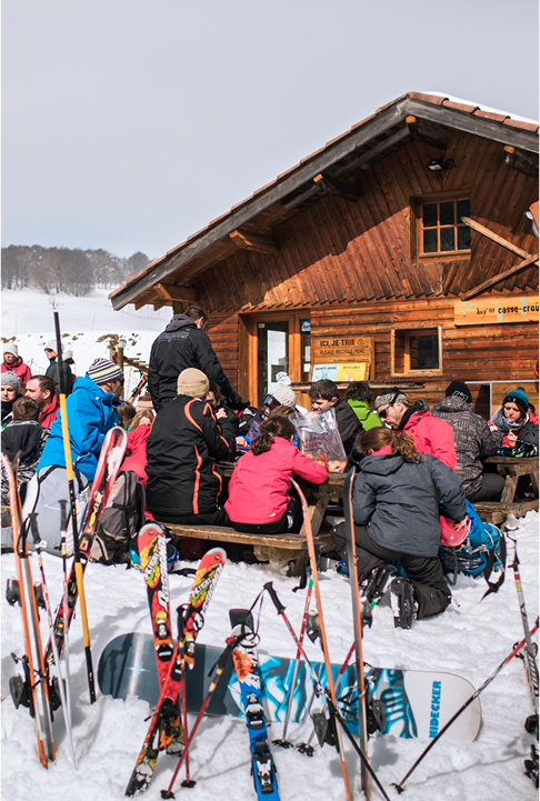 Groupe de skieurs en pause devant un chalet en bois à Prabouré.