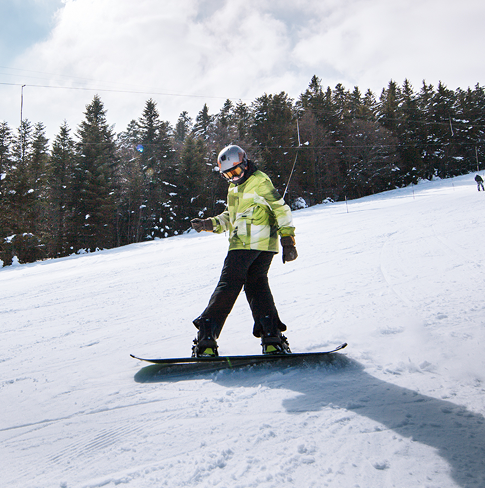 Snowboardeur descendant une piste enneigée à Prabouré.